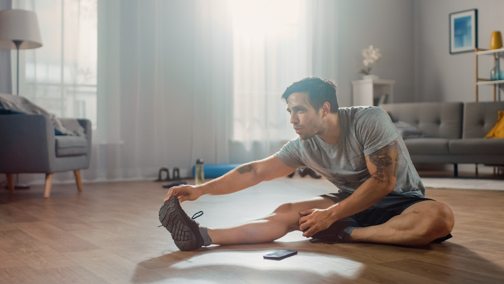 man does stretch in living room