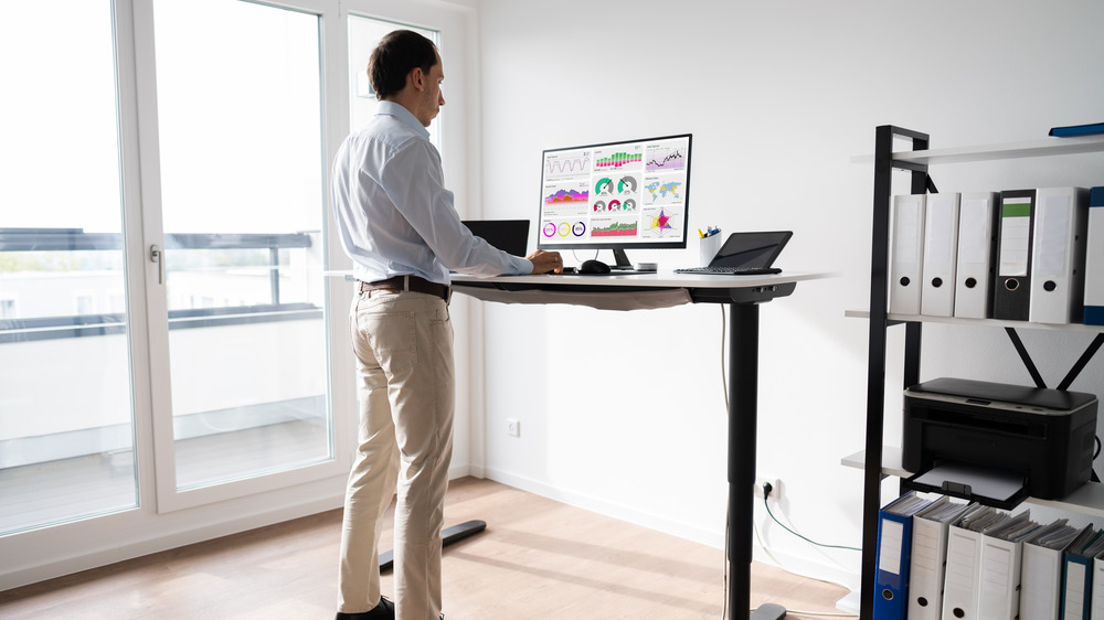 man at standing desk in office